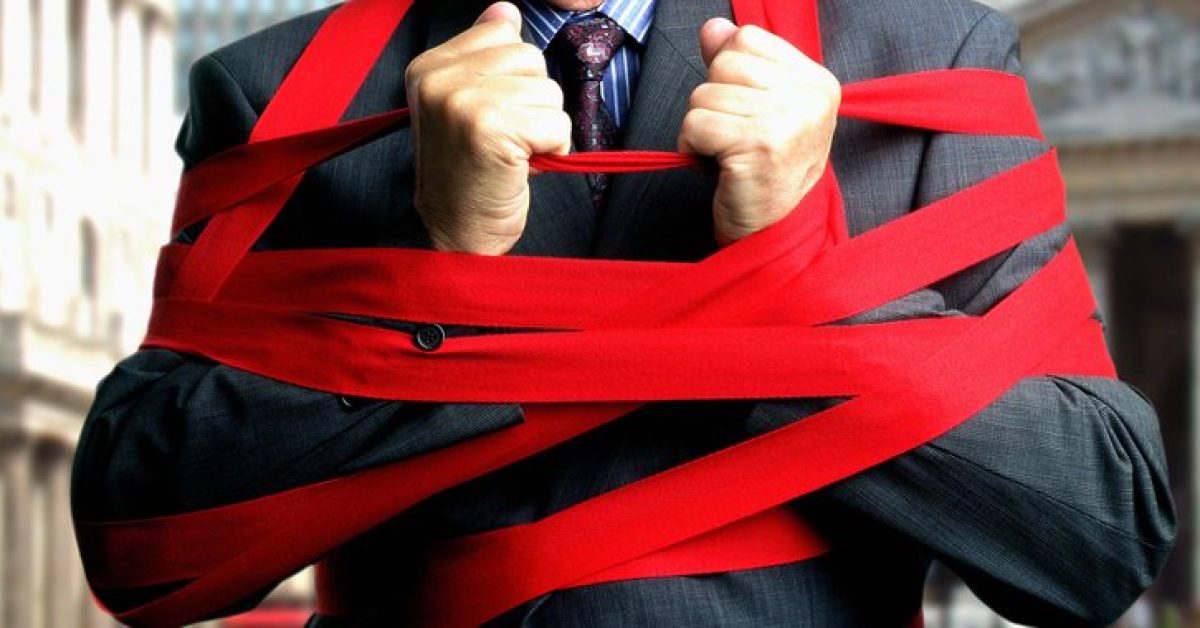 Businessman bound up in red tape, mid section, close-up